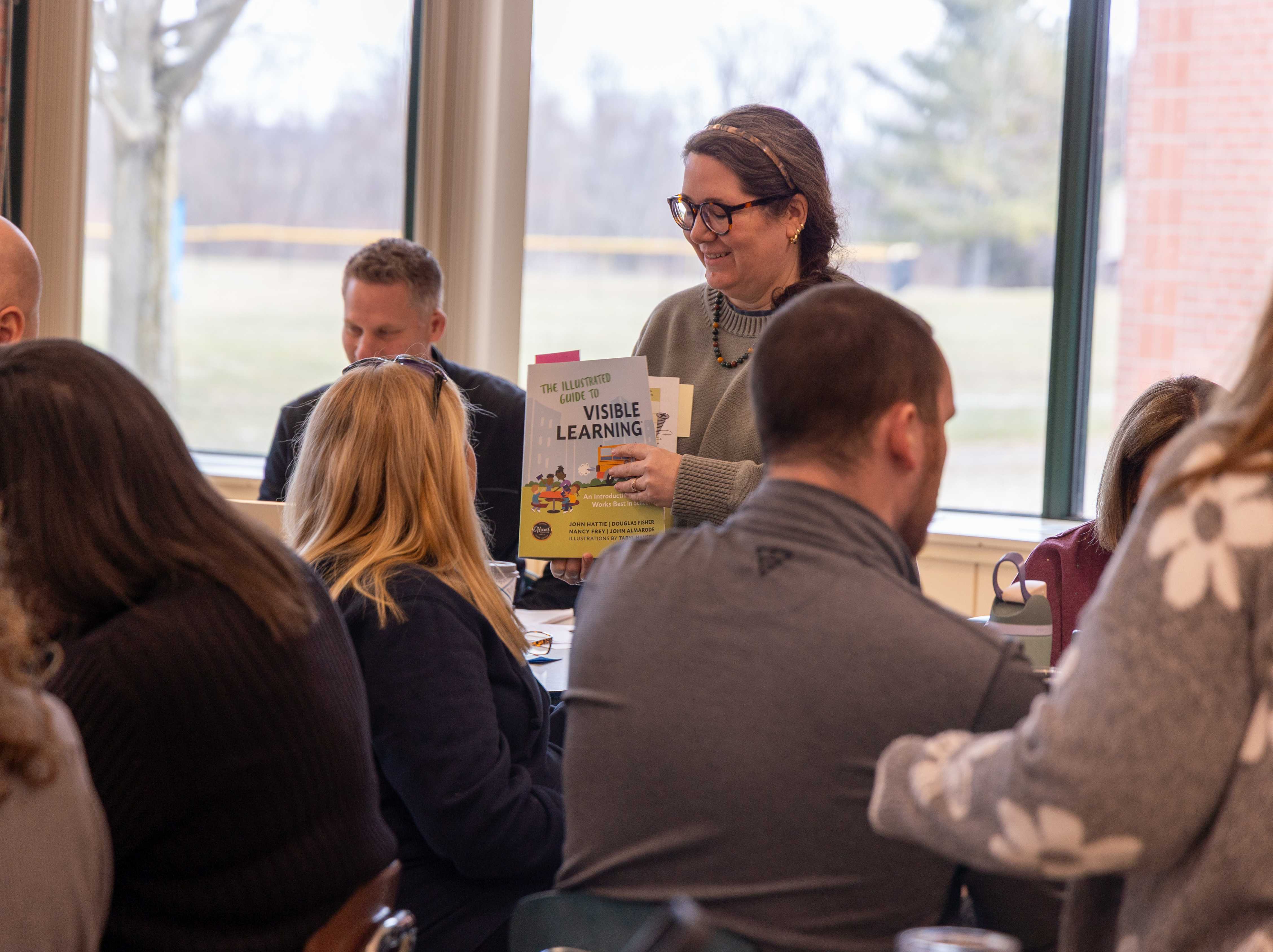 A faculty member hold the visible learning booklet
